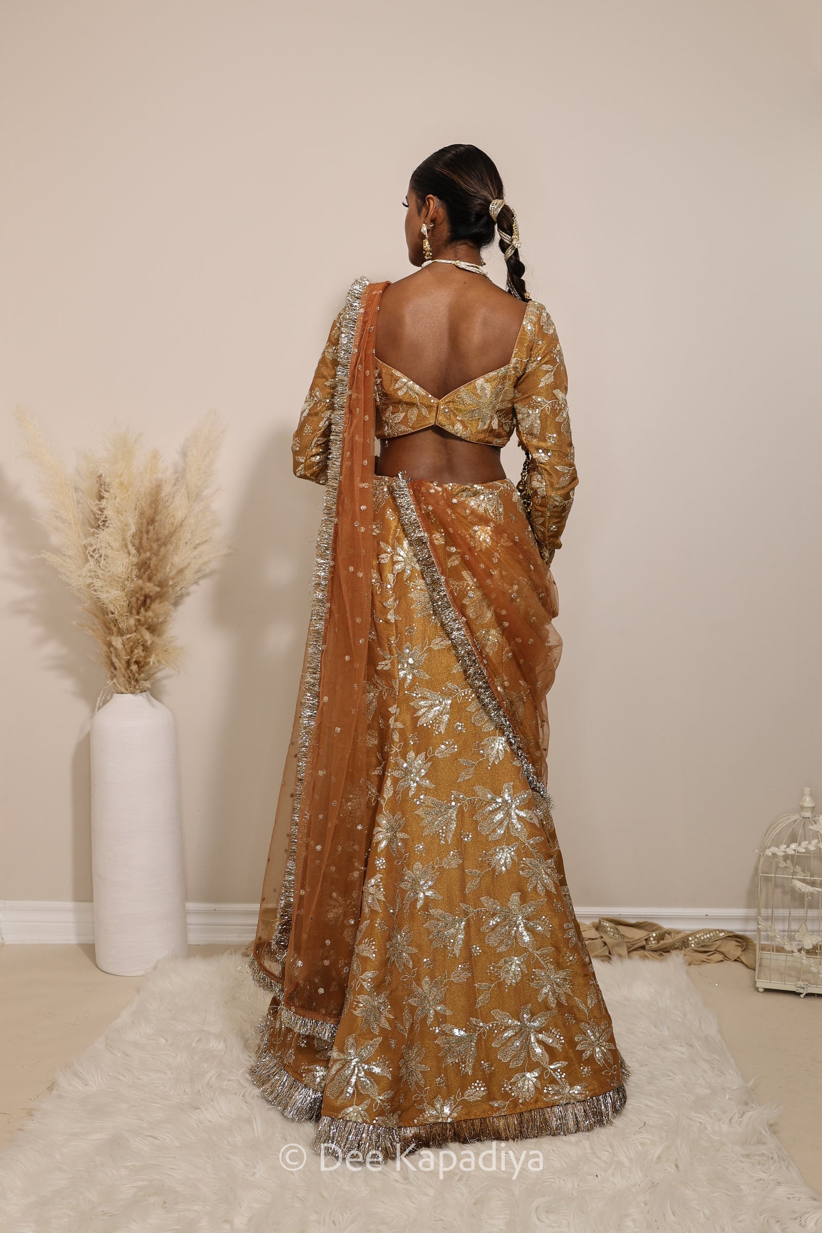 Woman in a floral yellow and gold/silver patterns traditional mermaid lehenga outfit with jewelry, with a sheer dupatta standing against a plain background. Lakshmi top with Vaani marmaid Lehenga front in espresso plum chocolate brown for wedding, bridal haldi, mehendi jaggo, sangeet indian wedding events 