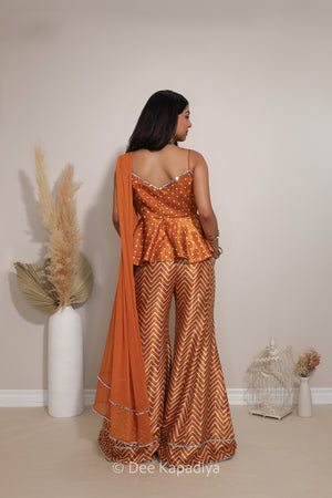 Back view of Dee Kapadiya Nakhra Gharara Set in Haldi showing the strappy peplum top and flowing chiffon dupatta