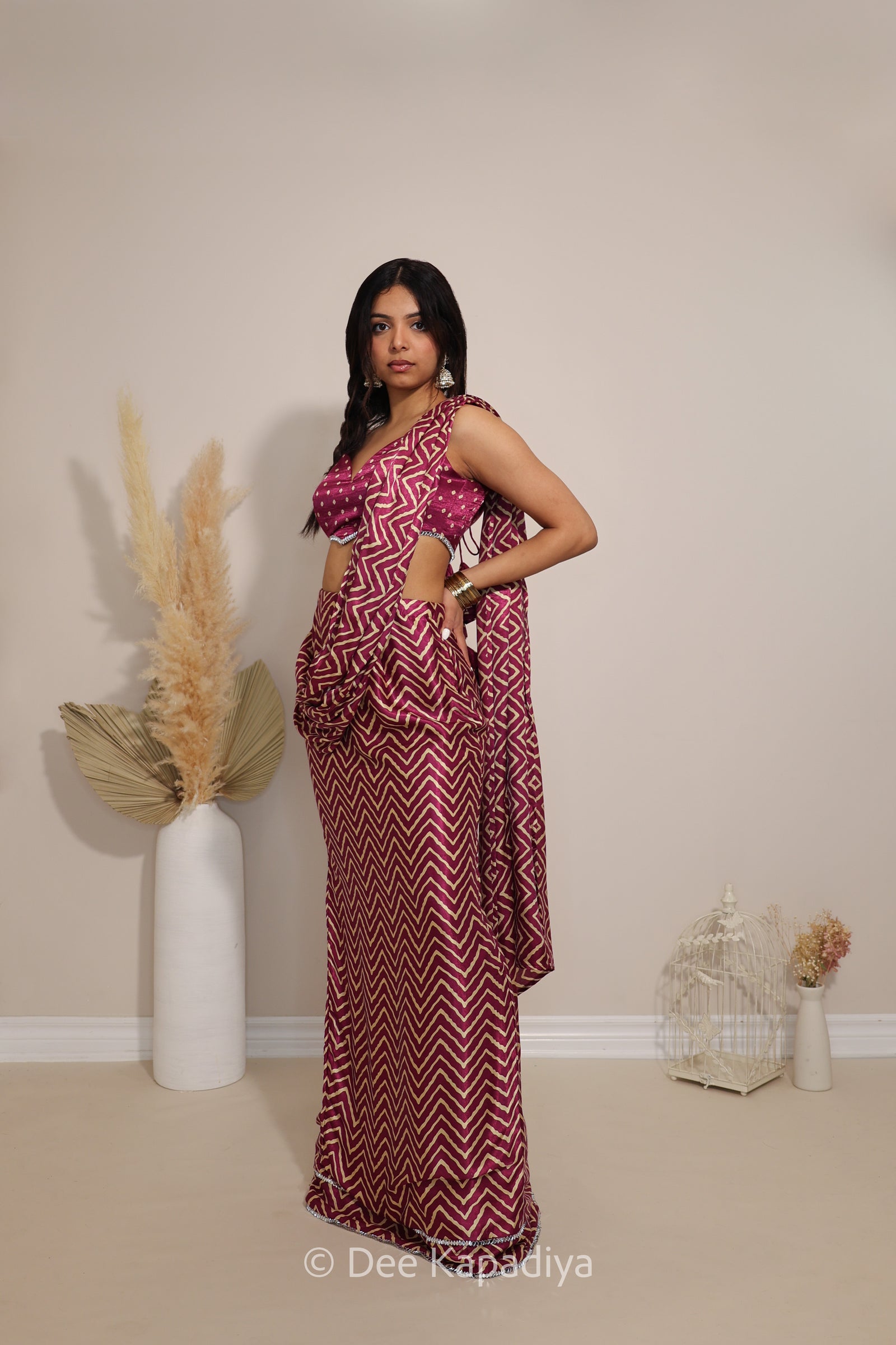 Model wearing Dee Kapadiya Pataka pre-draped Saree Set in Masala with Bandhani-print Phool crop top and chevron draped saree