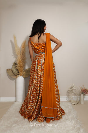 Back view of Dee Kapadiya Tamasha Lehenga Set in Haldi showing the bandhani print Pataka crop top straps and mirror-trimmed chevron lehenga