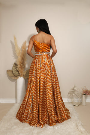 Back view of Dee Kapadiya Tamasha Lehenga Set in Haldi showing the bandhani print Pataka crop top straps and mirror-trimmed chevron lehenga