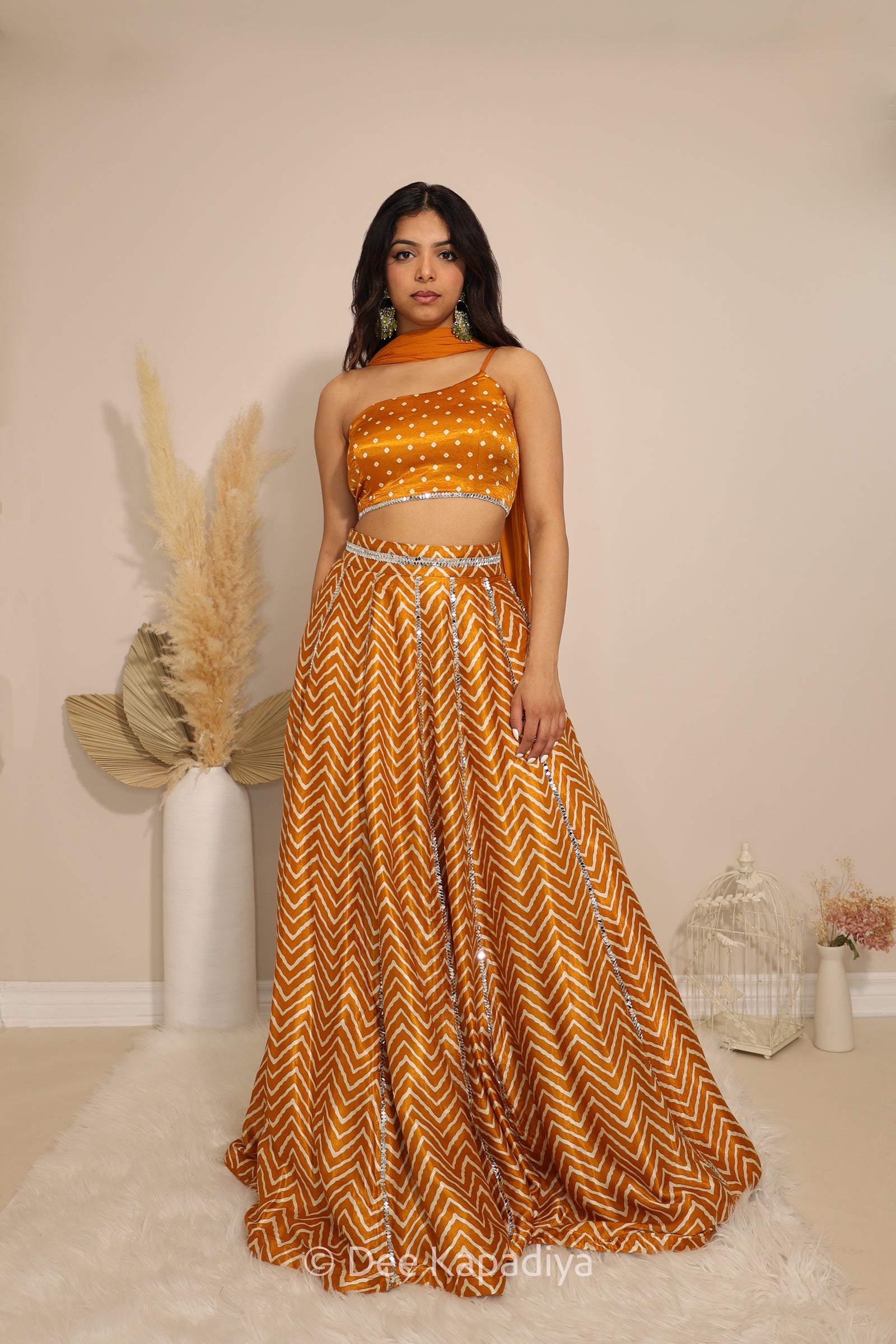 Model wearing Dee Kapadiya Tamasha Lehenga Set in Haldi with mirror-work bandhani print Pataka crop top, chevron lehenga and chiffon dupatta