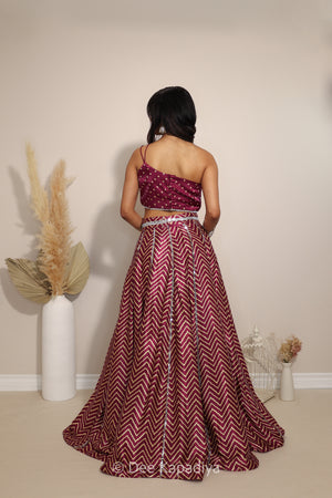 Back view of Dee Kapadiya Tamasha Lehenga Set in Masala showing the bandhani print Pataka crop top straps and flowing chevron lehenga