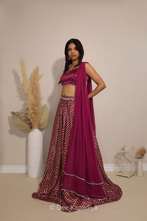 Model wearing Dee Kapadiya Tamasha Lehenga Set in Masala with mirror-work bandhani print Pataka crop top, chevron lehenga and chiffon dupatta